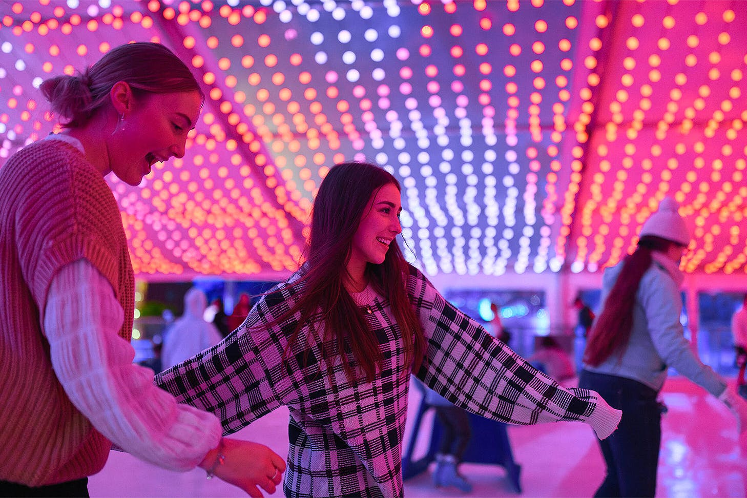 Two people enjoy the ice rink at Aotea Ice Rink.